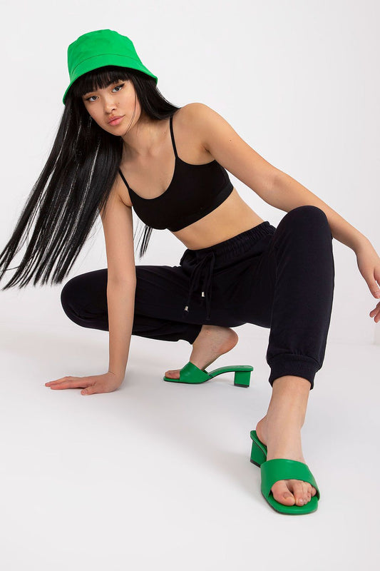 Close-up of a model in BFG High Rise Tracksuit Trousers with Drawstring Waist, emphasising flexibility and chic street style with vibrant green accessories.