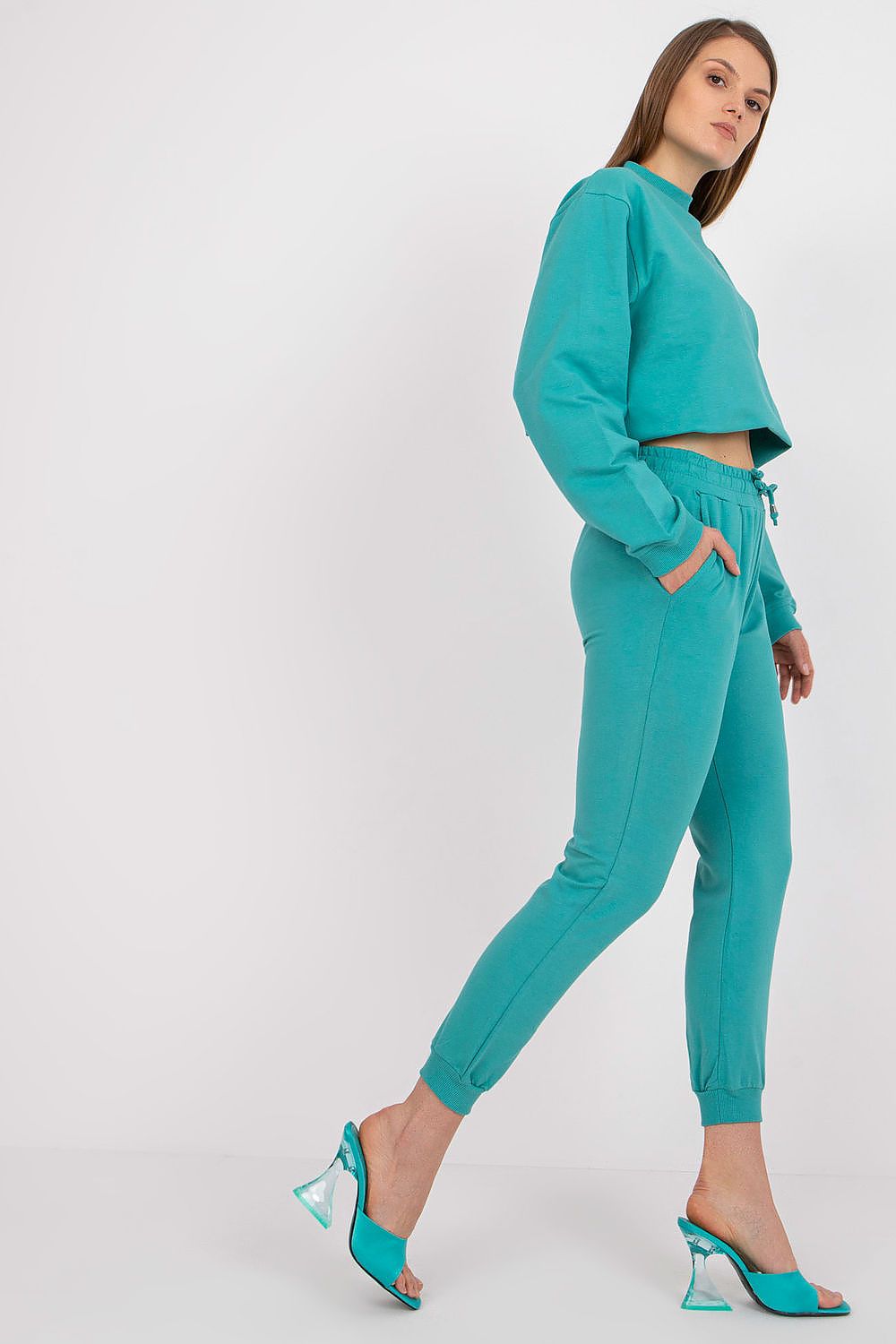 BFG High Rise Tracksuit Trousers with Drawstring Waist and Side Slash Pockets, side view of model wearing vibrant turquoise joggers, exuding elegance and casual sophistication.