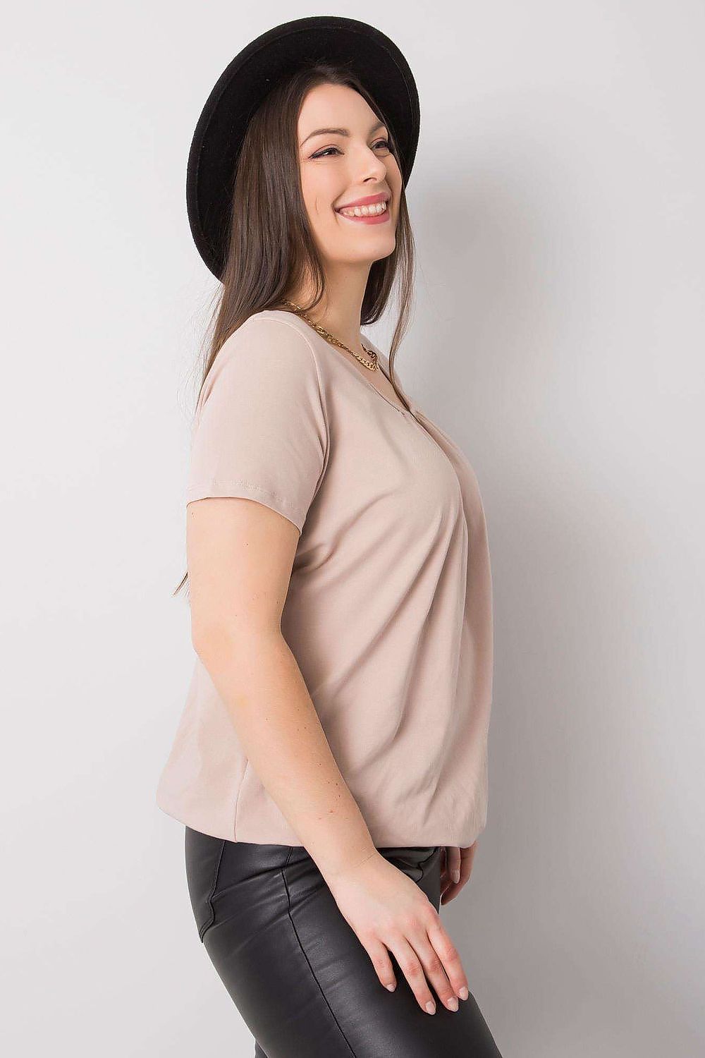 BFG Women's Plus Size T-Shirt showcased in smooth beige, elegantly draped with short sleeves and a round neckline, complemented by black leather trousers, versatile for upscale casual settings. Sizes 2XL to 4XL.