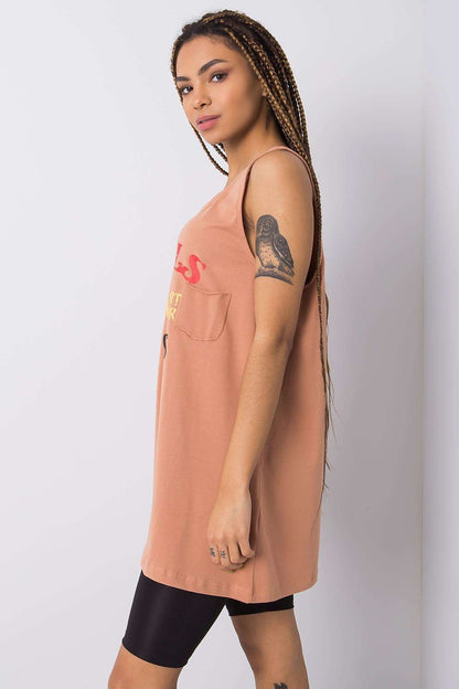 Side profile of a model in the Luxury Sleeveless Extended Cut T-Shirt with Decorative Inscription, showing the chic peach tank top detailed with 'GIRLS' lettering, paired stylishly with ethnic leggings.