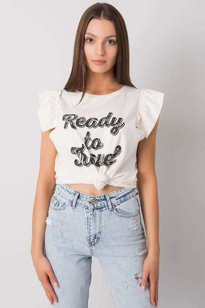 Trendy model wearing the Elegant Short Sleeve Frill Blouse with Decorative Inscription in white, knotted at the waist, demonstrating its versatile styling options.