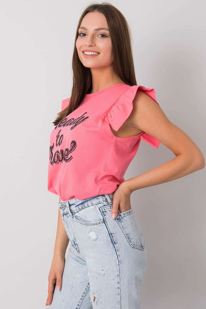 Elegant Short Sleeve Frill Blouse with Decorative Inscription - Cotton and Lycra Blend, showcasing a model in a pink version of the blouse with frill sleeves and 'Ready to Travel' inscription, highlighted by chic high-waisted jeans.