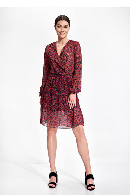 Elegant Figl Summer Mini Dress with Long Sleeves, Ruffle Hem, and Waist Detail, showcased on a model standing confidently with an enchanting floral design and stylish sandals.