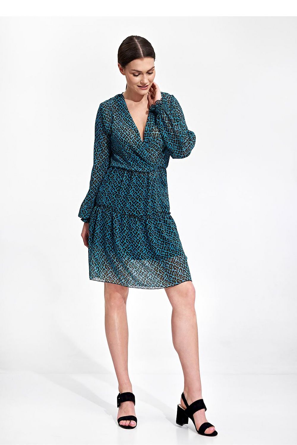 Elegant Figl Summer Mini Dress with Long Sleeves, Ruffle Hem, and Waist Detail, featuring a vibrant teal print, displayed on a model standing gracefully. Perfect for summer occasions.