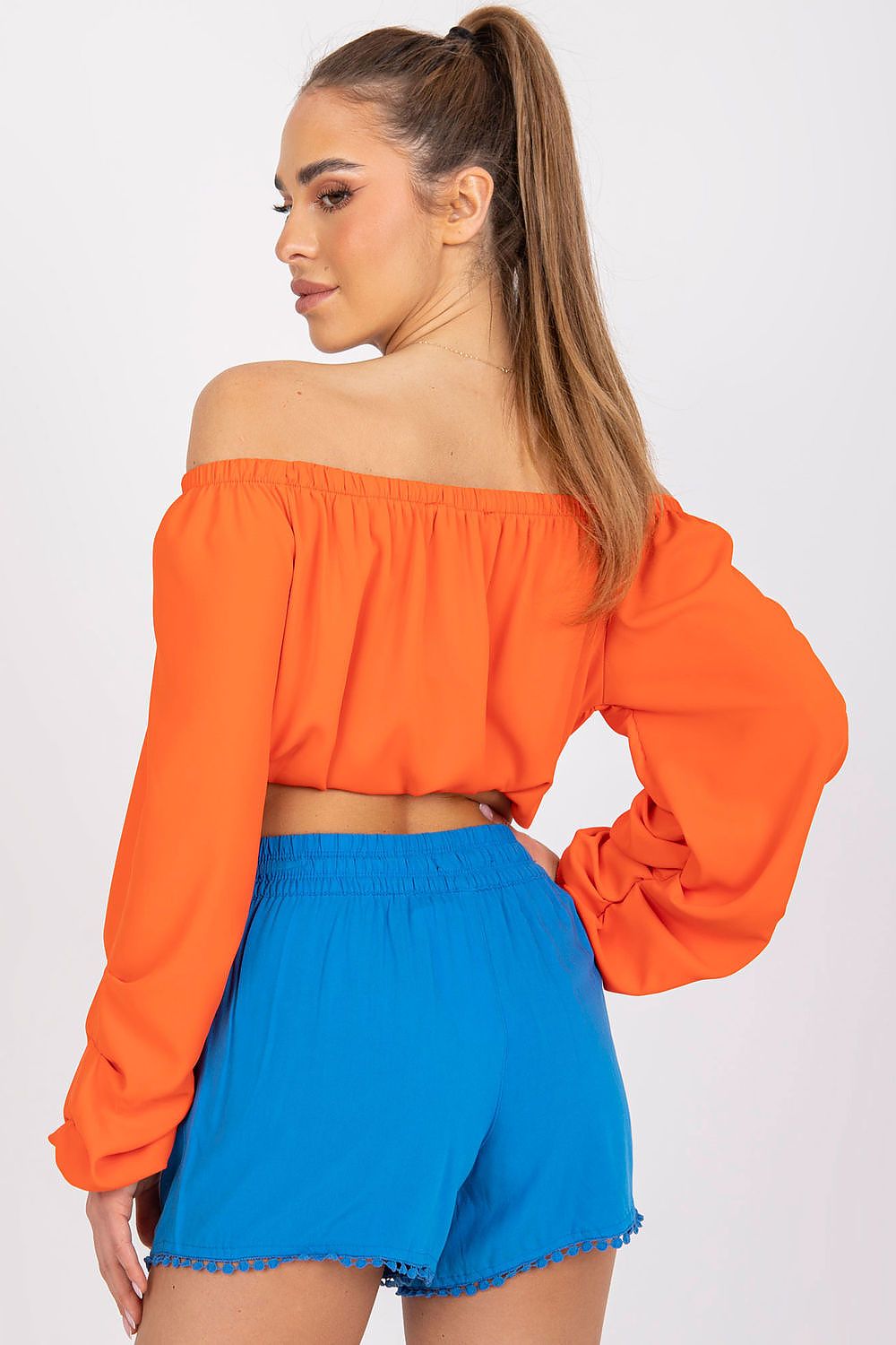Luxury Women's Viscose Shorts with Elastic Waist and Pockets - Fresh Made Essentials, showcasing a fashionable back view of a model in an off-shoulder orange top and blue shorts, radiating luxury and style.
