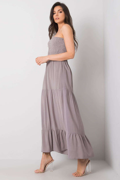 Side profile of a chic strapless long summer dress in solid grey with elastic smocked bodice and ruffle hem, made from luxurious 100% viscose by Fresh Made.