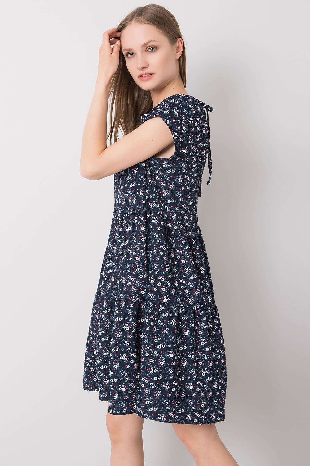 Elegant Loose-Fitting Daydress by Stitch&Soul featuring a side view of a model in a floral dress with a deep neckline at the back.