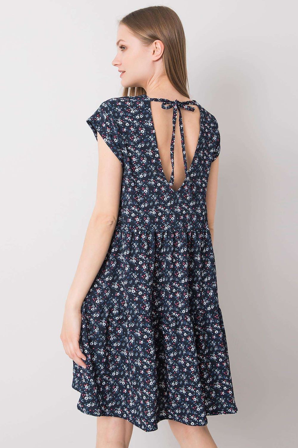 Elegant Loose-Fitting Daydress by Stitch&Soul highlighting the back detail of a model in a floral dress with a deep neckline and tie closure.