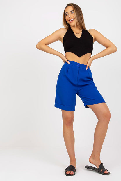 Elegant model in Xsapienza Higher-Waisted Shorts with Zipper Closure & Side Slip Pockets, styled in a black cropped top and blue shorts, radiating luxury.