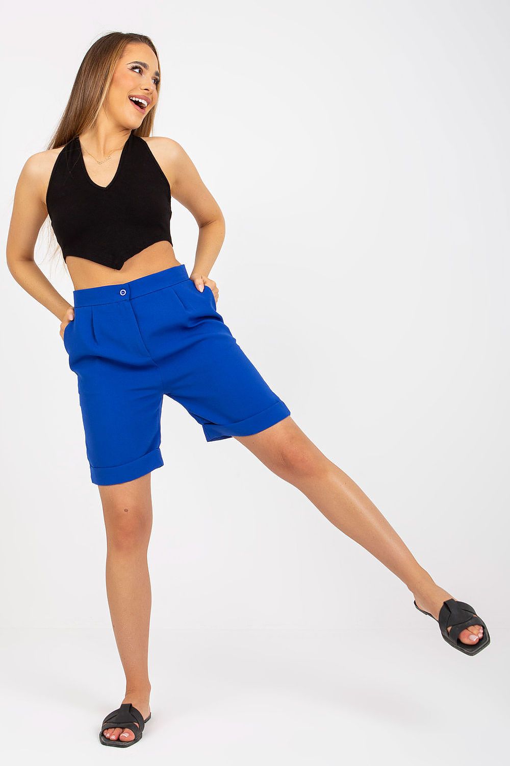 Playful model in Xsapienza Higher-Waisted Shorts with Zipper Closure & Side Slip Pockets in blue, paired with a black crop top, showcasing a luxurious fashion statement.