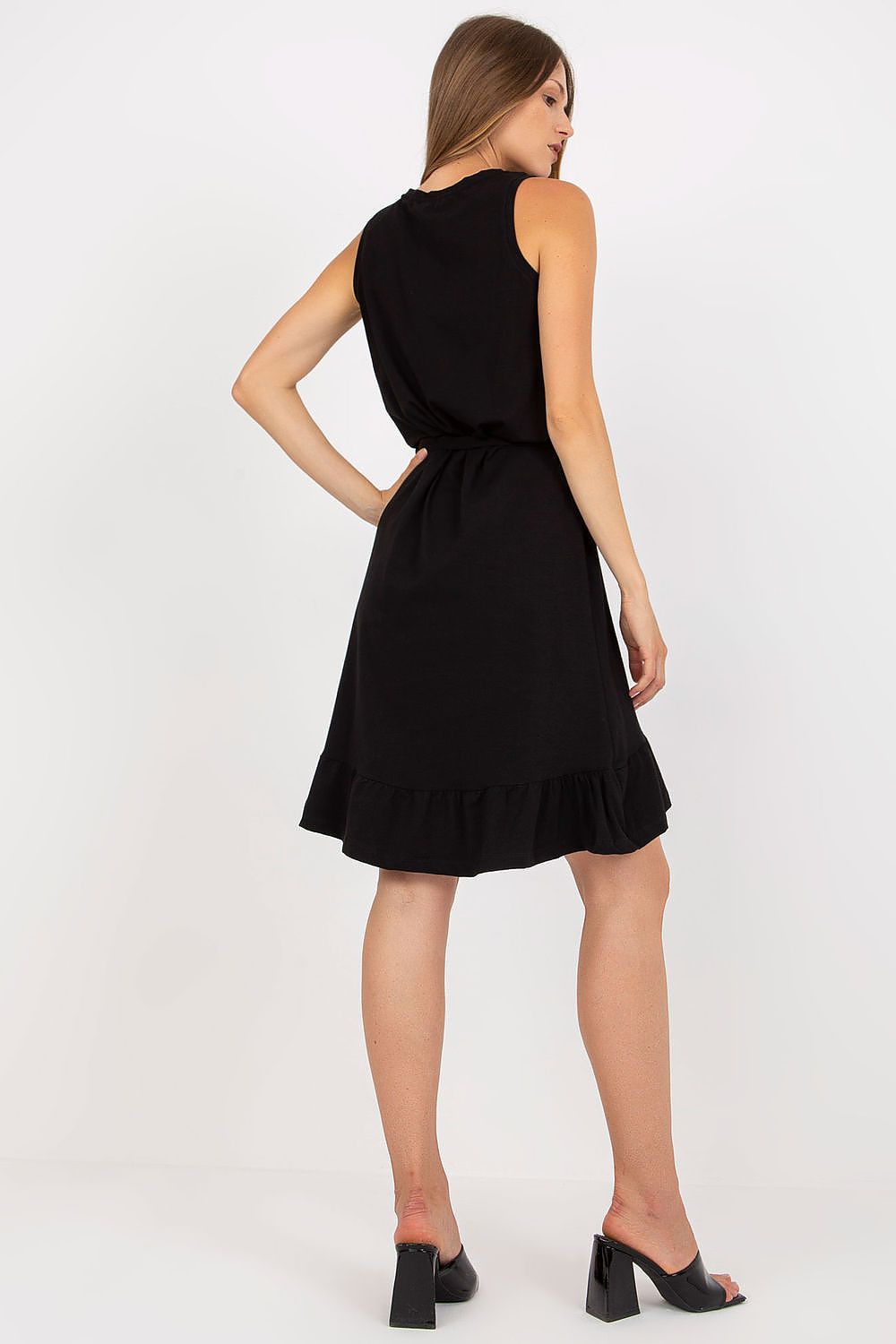 Back view of the Elegant Asymmetrical Flared Summer Dress with Ruffle & Sweetheart Neckline by Rue Paris, highlighting the ruffle hem and waist tie detail, worn by a model in black.