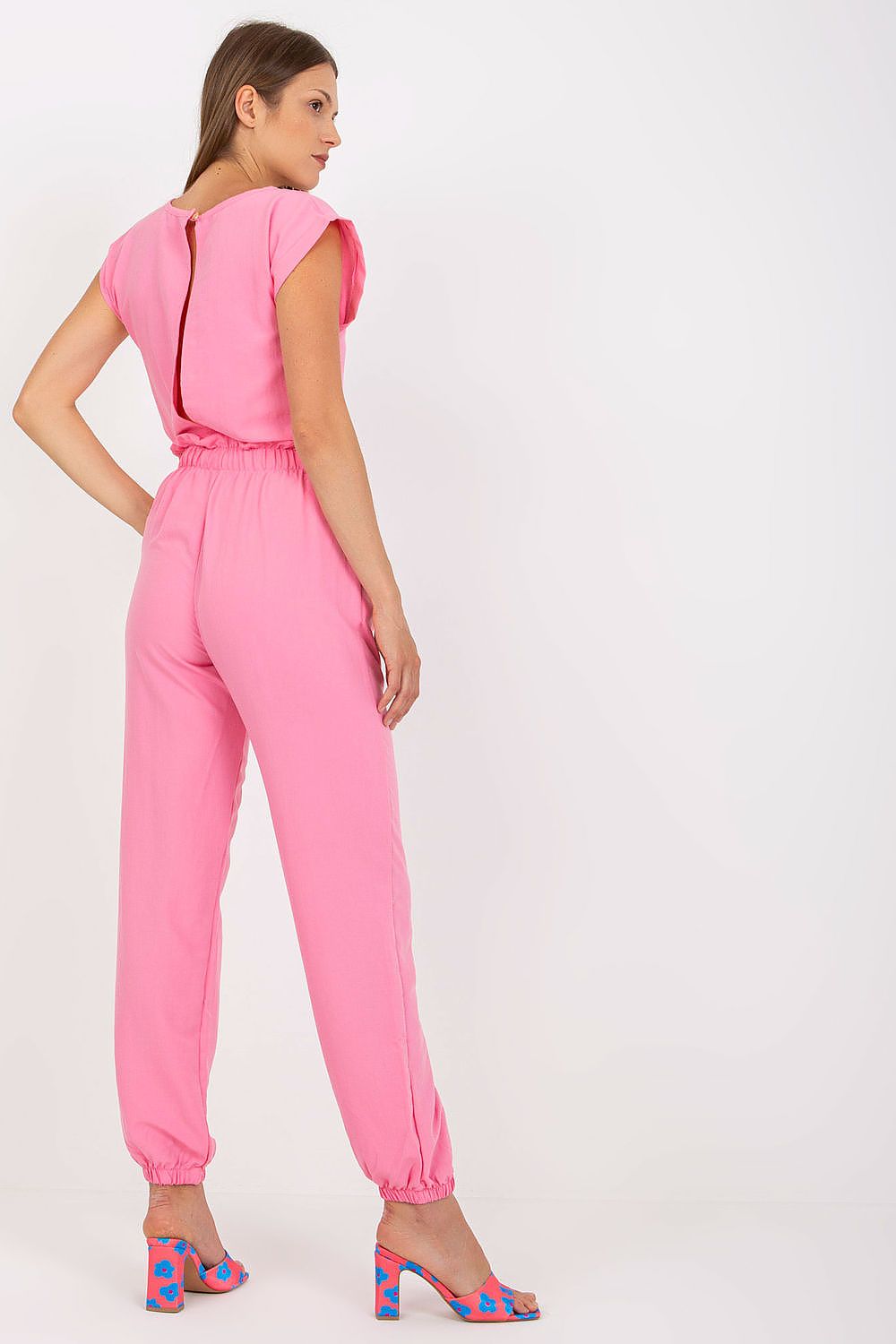 Back view of the Elegant Rue Paris Summer Set in pink, illustrating the elegant blouse design with a chic neck fastening and the relaxed long pants with elastic cuffs.
