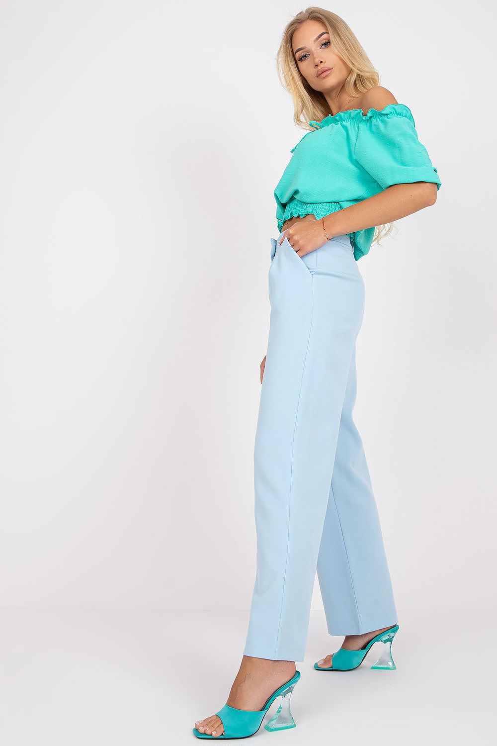 Luxurious Wide Leg Women’s Trousers by Rue Paris - Stylish Fabric Pants with Pockets. View of a model in light blue trousers, accentuated by a stylish side profile and complementary turquoise top.