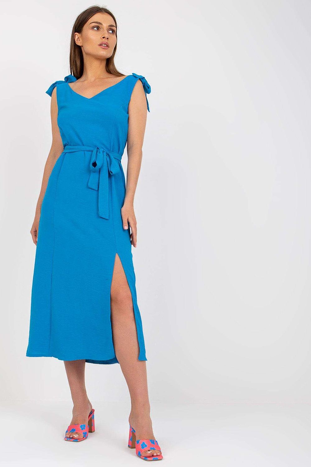 Elegant Summer Dress with Tied Straps and Slit by Rue Paris, model gracefully posing in a stunning blue dress with tied straps and a stylish slit for a sophisticated summer look.