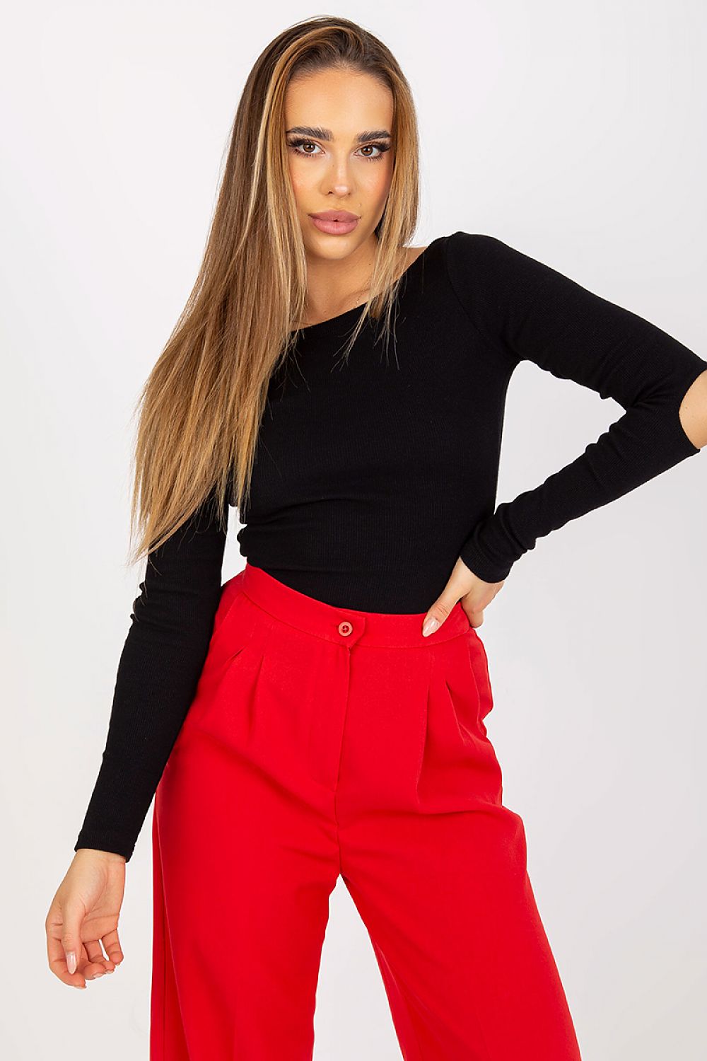 Elegant Long Sleeve Blouse with Boat Neckline and Decorative Slits - Rue Paris, model poses confidently in black blouse paired with bold red trousers.