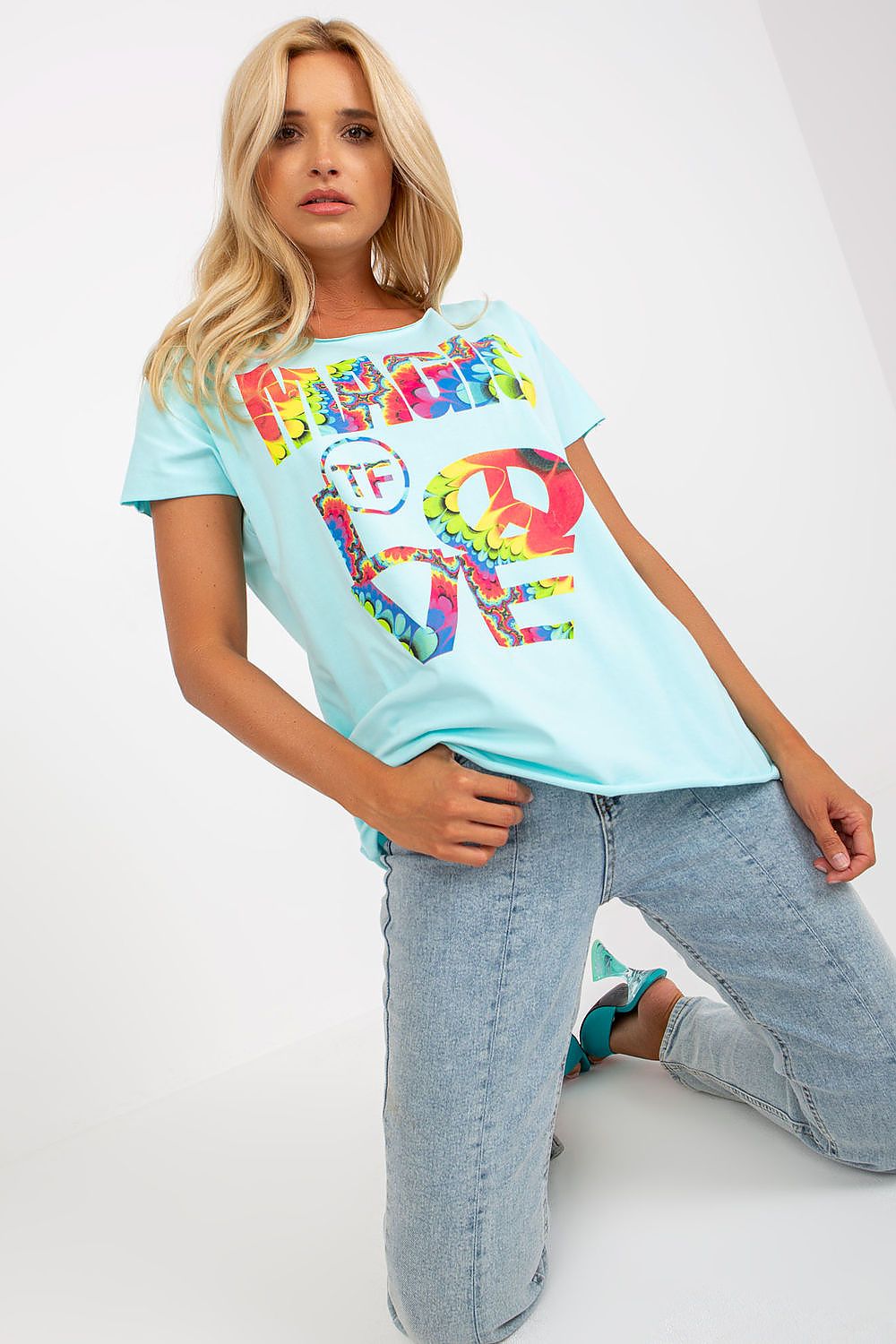 Elegant Straight Cut Cotton Spandex Blouse with Decorative Print – Short Sleeves, EU Size 0, model in a stylish pose wearing the blouse in light blue, highlighting its relaxed fit and colourful design.