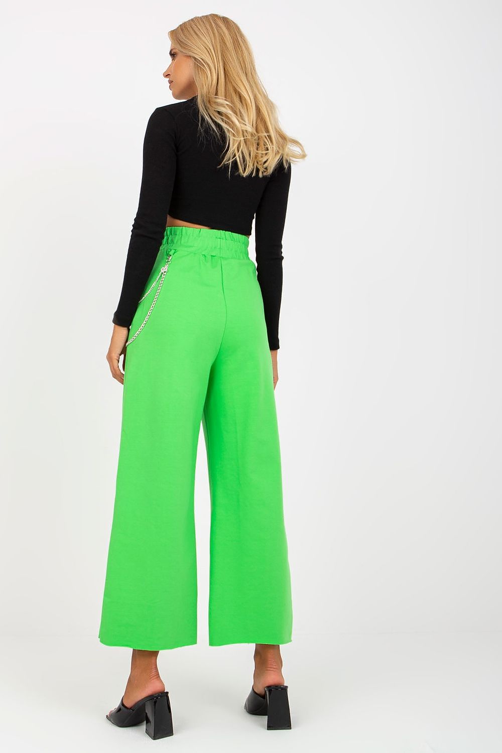 Back view of Luxury Women's Wide Leg Sweatpants with Pockets, Elastic Waistband and Decorative Slits, in bright green, perfectly paired with a fitted black top.
