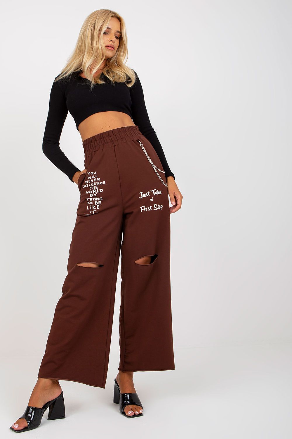 Fashionable model wearing Luxury Women's Wide Leg Sweatpants with Pockets, Elastic Waistband and Decorative Slits, in rich brown, accentuated by a chic black crop top.
