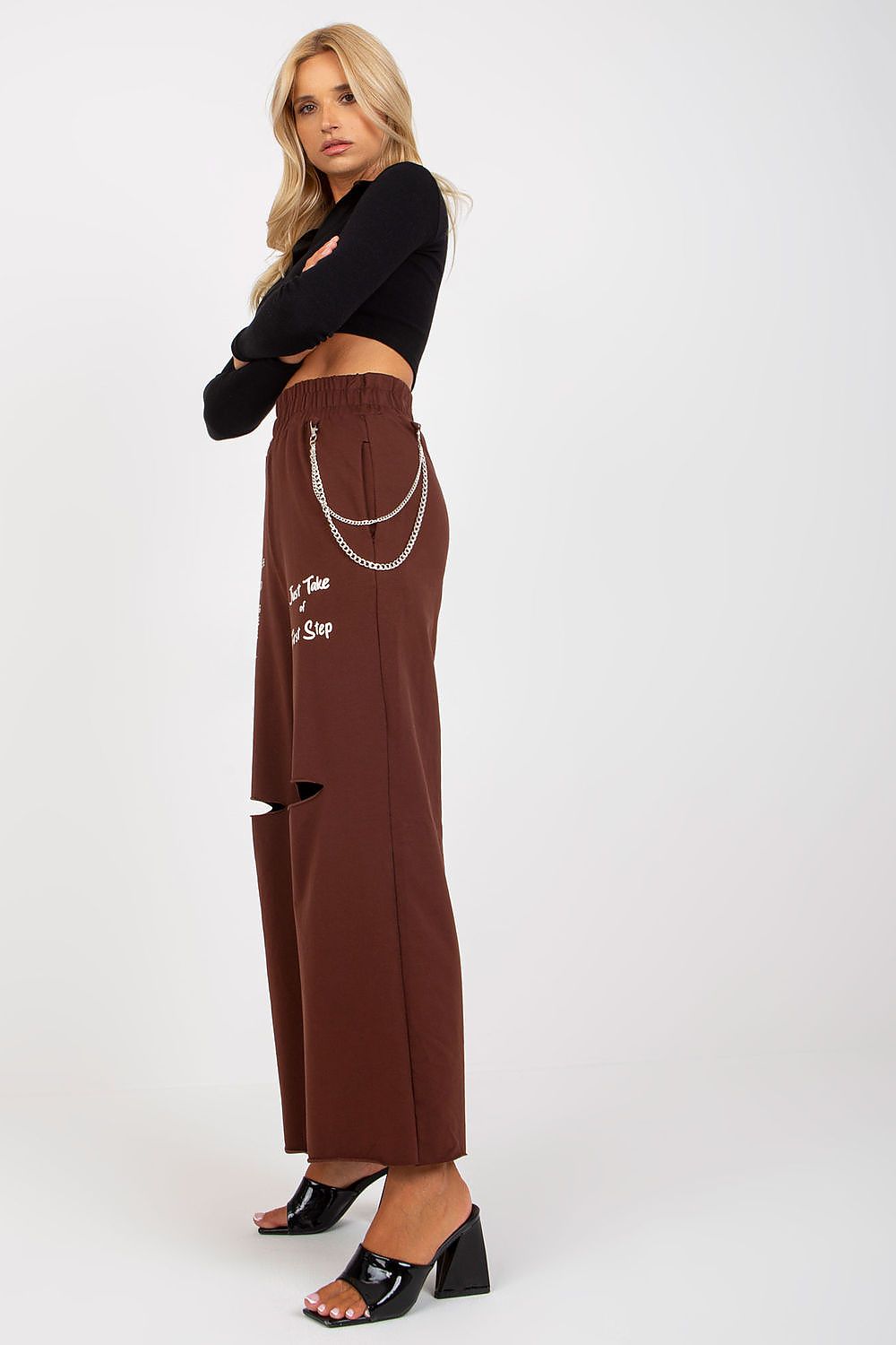 Side view of elegant model in Luxury Women's Wide Leg Sweatpants with Pockets, Elastic Waistband and Decorative Slits, showcasing a luxurious brown colour with stylish embellishments.
