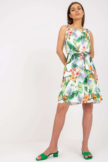 Elegant Summer Dress by Rue Paris with Colorful Pattern, Tied Straps, and Flattering Ruffles, model posing gracefully, featuring a tropical floral print complemented by stylish green heels.