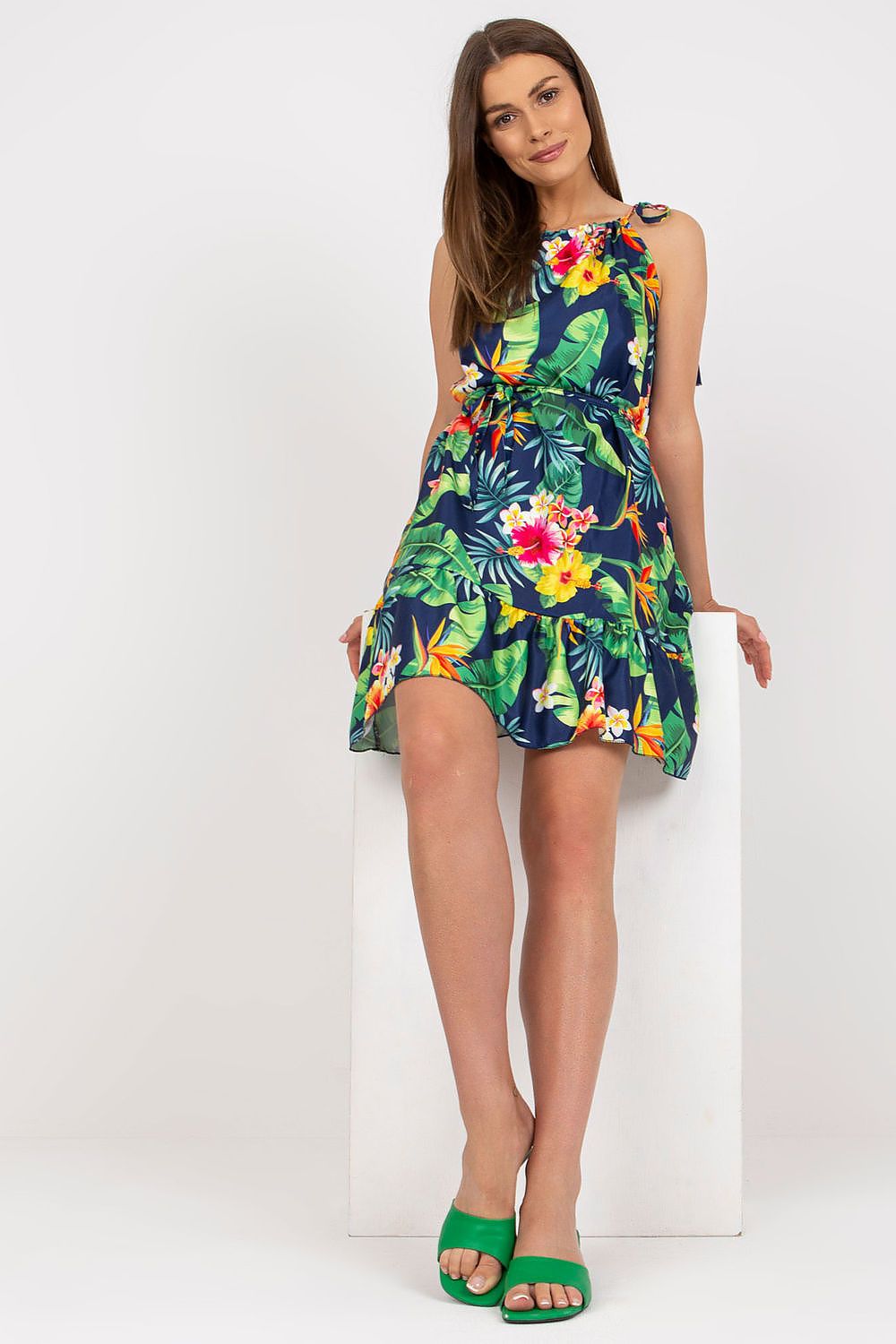 Elegant Summer Dress by Rue Paris with Colorful Pattern, Tied Straps, and Flattering Ruffles, model standing elegantly in a tropical floral ensemble, embodying summer chic style.
