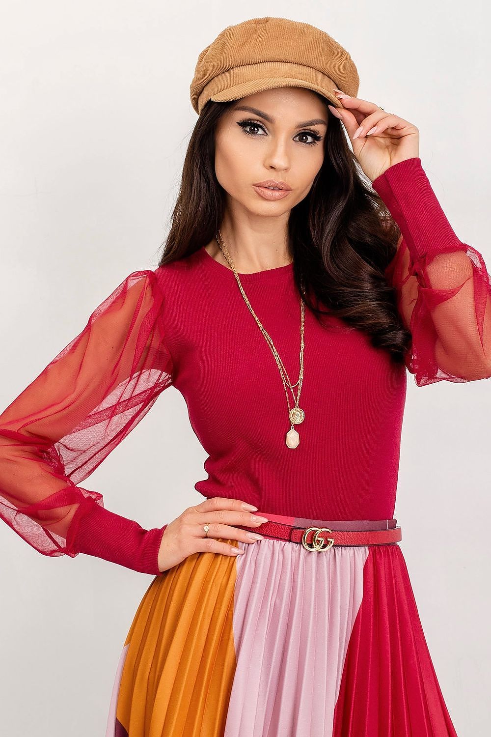 Elegant Rue Paris Visionary Blouse with Long Transparent Sleeves - Cotton and Spandex Blend, model showcasing a stunning red blouse with flowing sheer sleeves, styled with a fashionable pleated skirt and chic accessories.