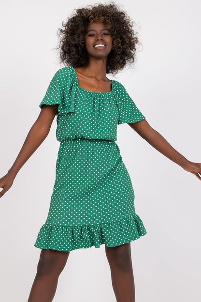 Luxury Cotton Ruffle Dress with Spanish Neckline by Rue Paris – Elegant Summer Daydress styled on a model with curly hair, showcasing the green colour and glamorous ruffle details.