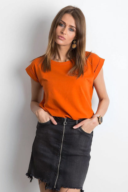 Stylish front view of a woman in an orange Women's Luxurious BFG Cotton Spandex T-Shirt with short sleeves, perfectly complemented by a black denim skirt.
