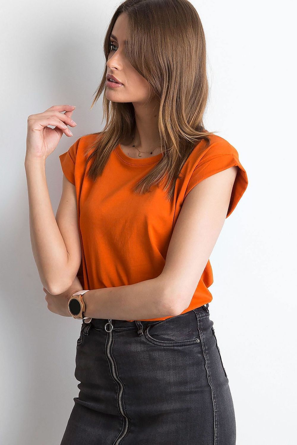 Trendy back view of a woman sporting an orange Women's Luxurious BFG Cotton Spandex T-Shirt with short sleeves, paired with stylish jeans for a casual yet luxurious look.