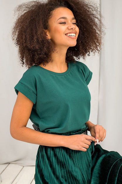 Joyful model wearing Women's Luxurious BFG Cotton Spandex T-Shirt in lush green, styled with a pleated velvet skirt, radiating elegance and sophistication.