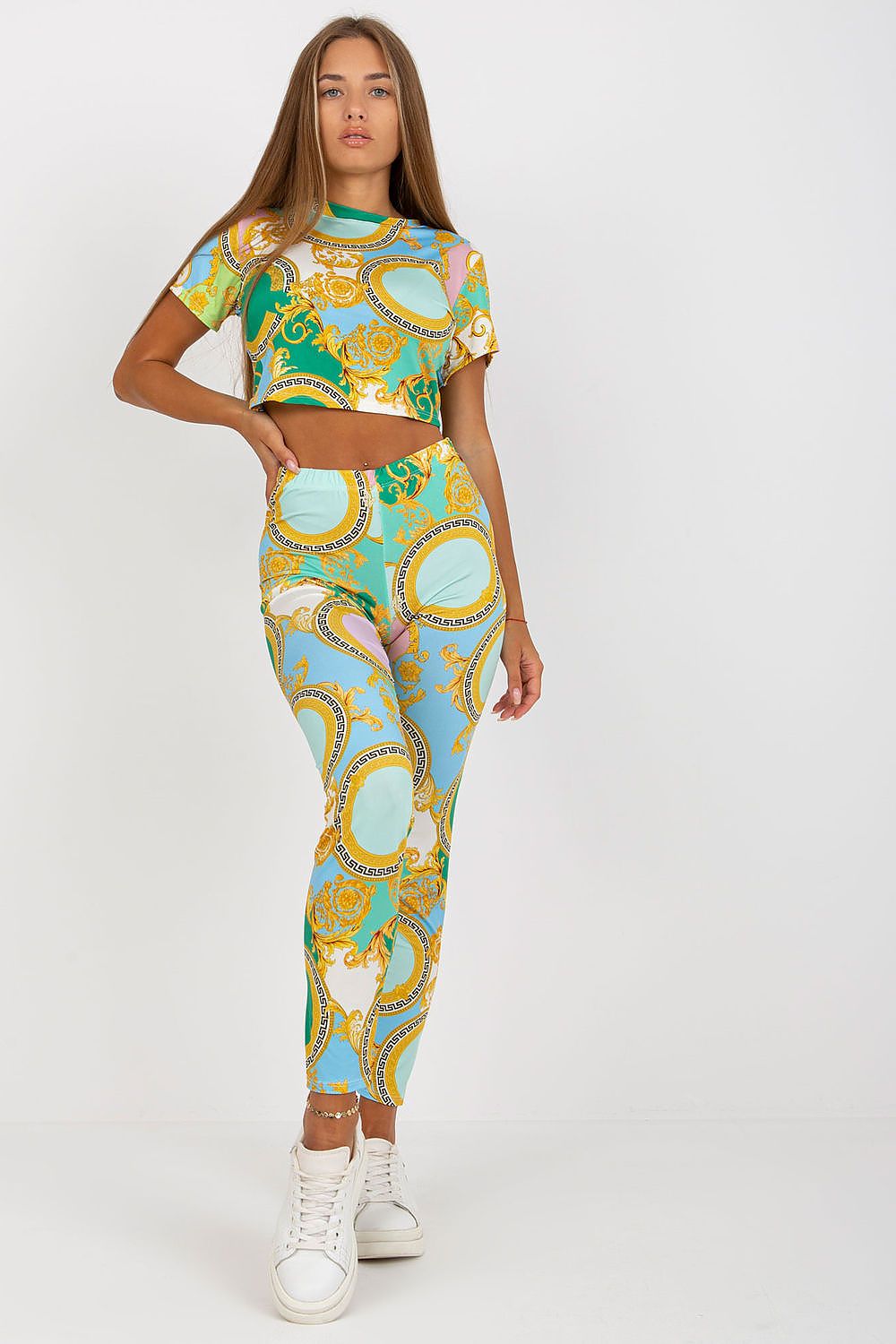 Women’s Luxury High-Rise Trousers with Elastic Waist and Pockets by Italy Moda, model sitting confidently on a sofa, highlighting the exquisite design and vibrant colours of the outfit.