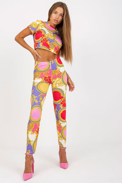 Model showcasing Italy Moda's luxury high-rise trousers for women, complete with elastic waist and pockets, in eye-catching red, pink, and golden designs complemented by striking pink heels.