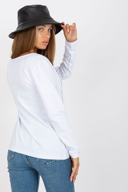 Elegant Long Sleeve Blouse By Rue Paris With Deep Neckline And Binding Detail, back view of a model in a white long sleeve blouse, highlighting the binding detail while holding a black bucket hat.