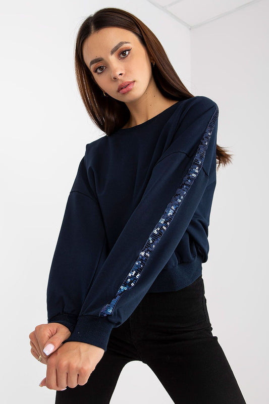 Luxury Rue Paris Women's Sequined Long Sleeve Sweatshirt with Round Neckline - Elegant Comfort, featuring intricate sequined detailing on sleeves, styled with a round neckline and paired with black jeans.