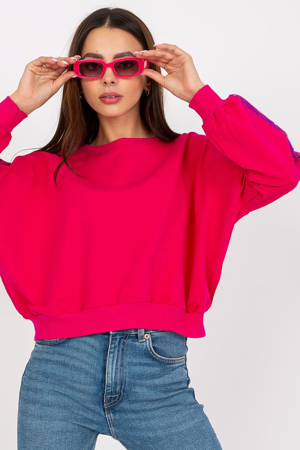 Luxury Rue Paris Women's Sequined Long Sleeve Sweatshirt with Round Neckline - Elegant Comfort, a model striking an elegant pose in a bright pink sweatshirt, enhancing its luxurious appeal.