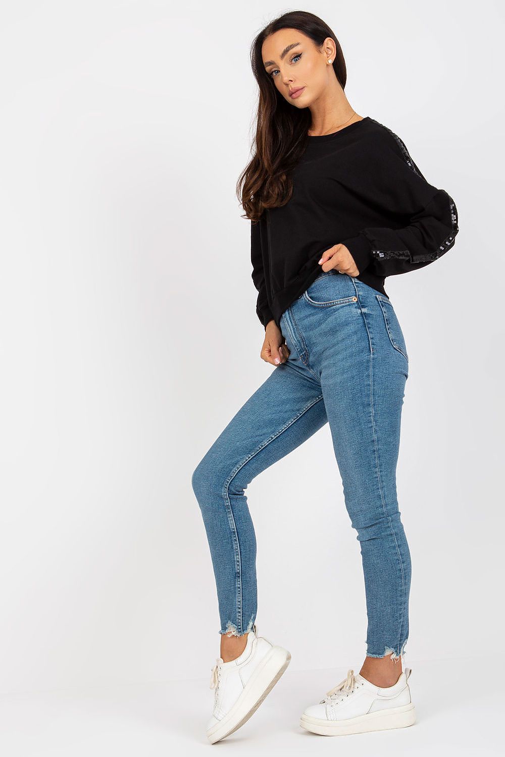Luxury Rue Paris Women's Sequined Long Sleeve Sweatshirt with Round Neckline - Elegant Comfort, featuring a model in a sophisticated black sweatshirt paired with blue fitted jeans and stylish footwear.