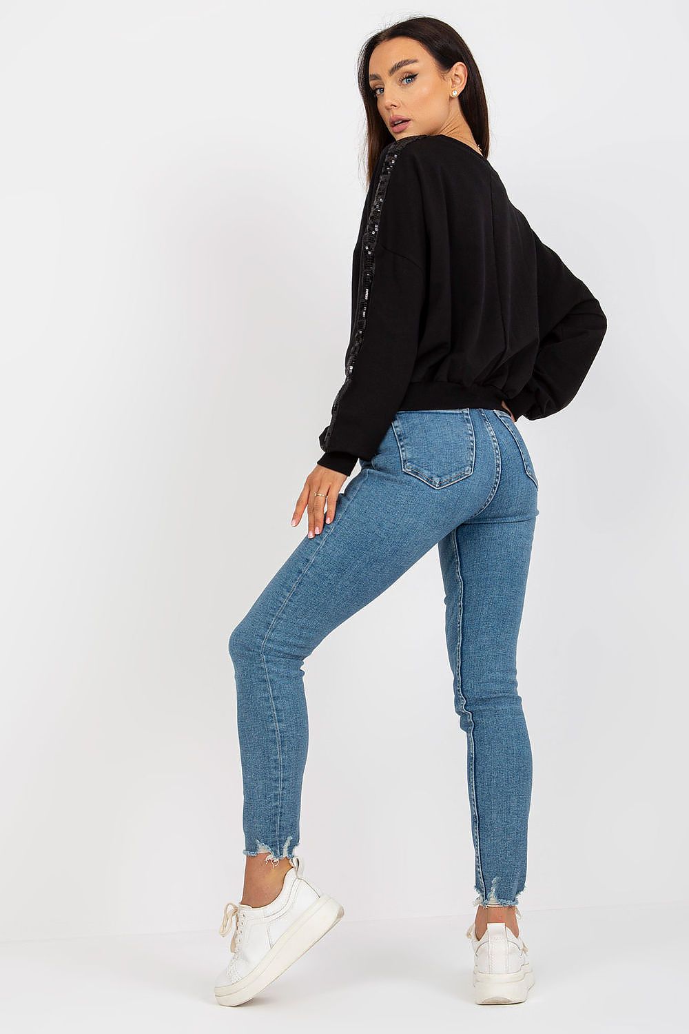 Luxury Rue Paris Women's Sequined Long Sleeve Sweatshirt with Round Neckline - Elegant Comfort, featuring a stylish model showcasing the black sequined sweatshirt paired with fitted blue jeans and white sneakers, perfect for a chic casual look.