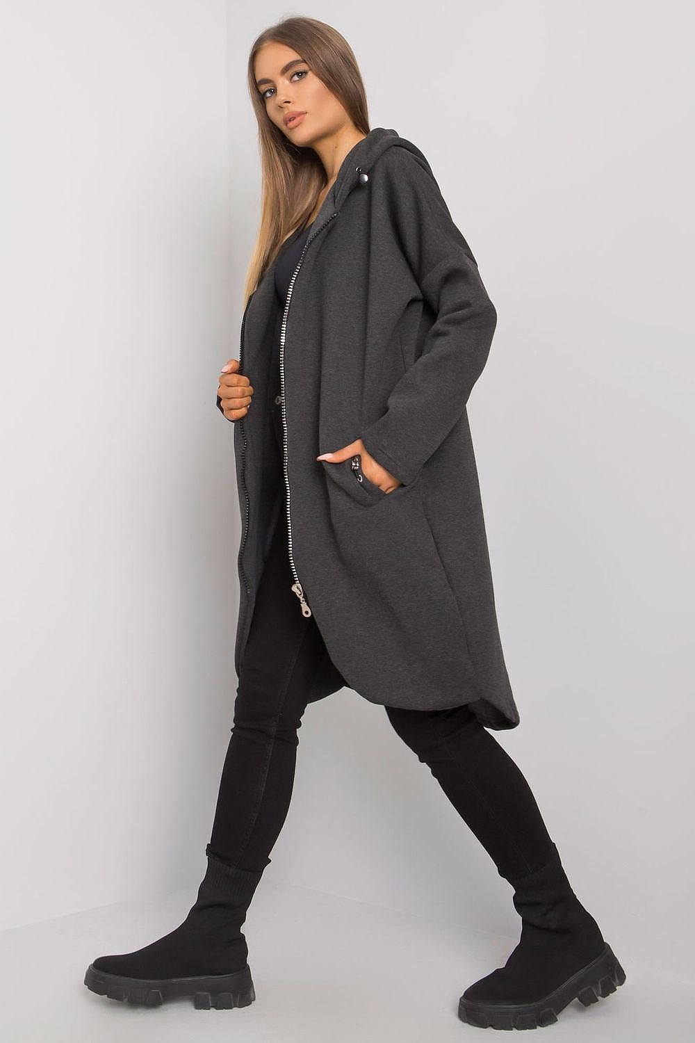 Fashionable Rue Paris Zip-Up Extended Cut Sweatshirt with Hood and Side Pockets in a tasteful grey hue, presenting a refined look with its spacious design and modern details.