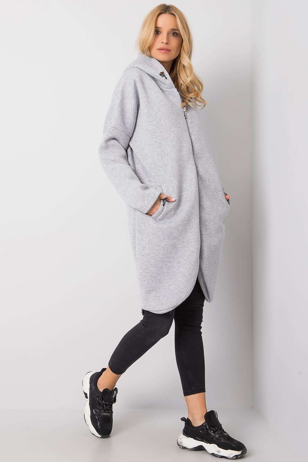 Rue Paris Zip-Up Extended Cut Sweatshirt with Hood and Side Pockets presented in grey, featuring a relaxed silhouette and side pockets, styled with black leggings and fashionable trainers.