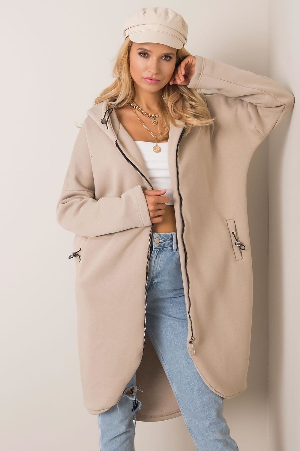 Chic Rue Paris Zip-Up Extended Cut Sweatshirt with Hood and Side Pockets in a neutral beige tone, paired with stylish high-waisted jeans, capturing a sophisticated yet relaxed aesthetic.