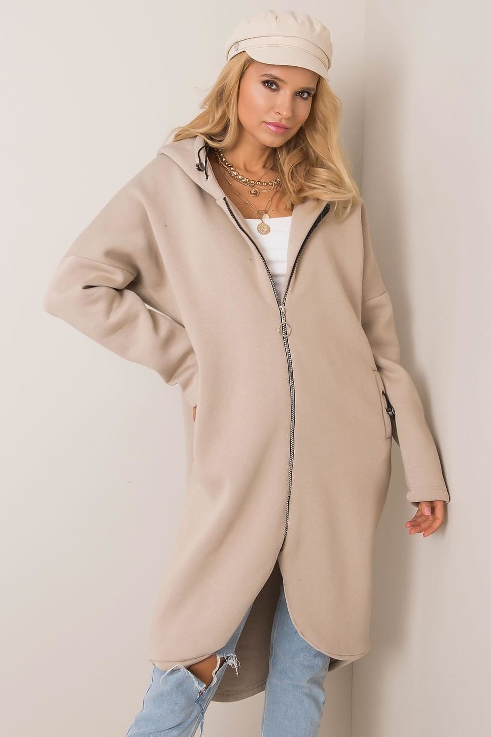 Stylish Rue Paris Zip-Up Extended Cut Sweatshirt with Hood and Side Pockets, elegantly showcased alongside distressed denim, exuding a fashionable and sophisticated aura.