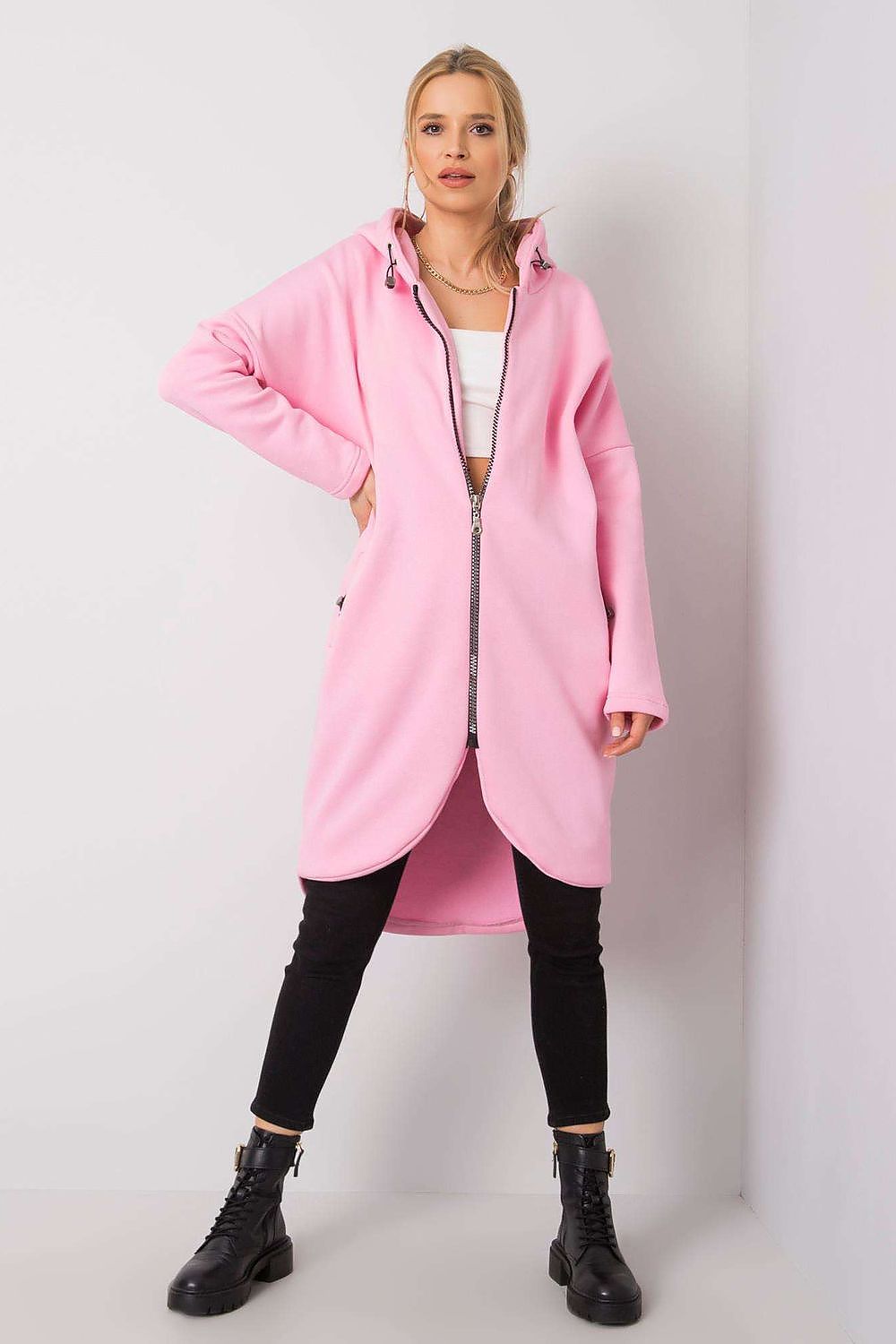 Bold Rue Paris Zip-Up Extended Cut Sweatshirt with Hood and Side Pockets in striking pink, styled with fitted black trousers and statement boots, perfect for an eye-catching, luxurious appearance.