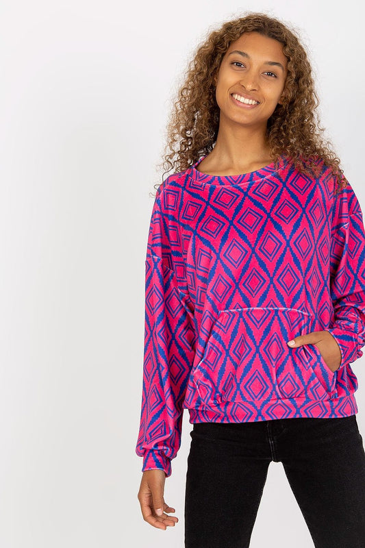 Elegant Rue Paris Women's Long Sleeve Sweatshirt featuring a chic kangaroo pocket and a vibrant geometric pattern, showcased by a smiling model with curly hair.