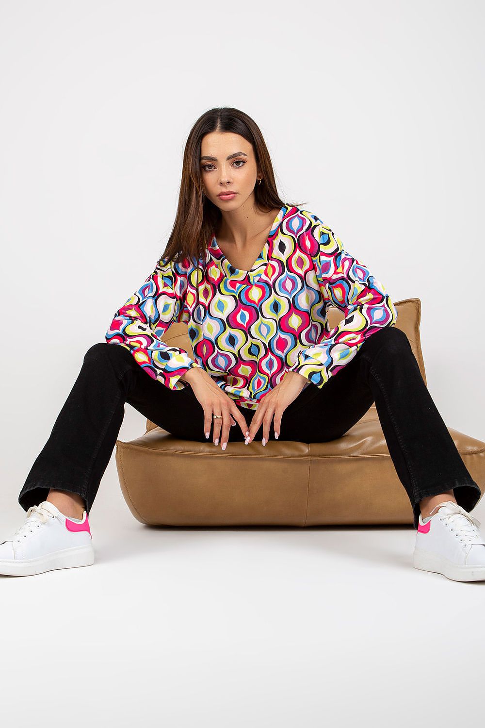 Luxurious Women's Sweatshirt with Heart Neckline and Unique Pattern by Rue Paris, model in a stylish pose sitting on a modern chair, emphasising comfort and trendy pattern.