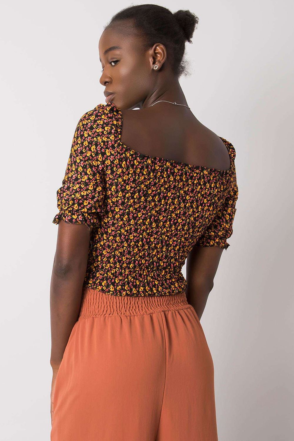 Rear perspective of an elegant fitted cotton blouse with v-neck and short sleeves from Rue Paris, highlighting the floral design and fitted silhouette.