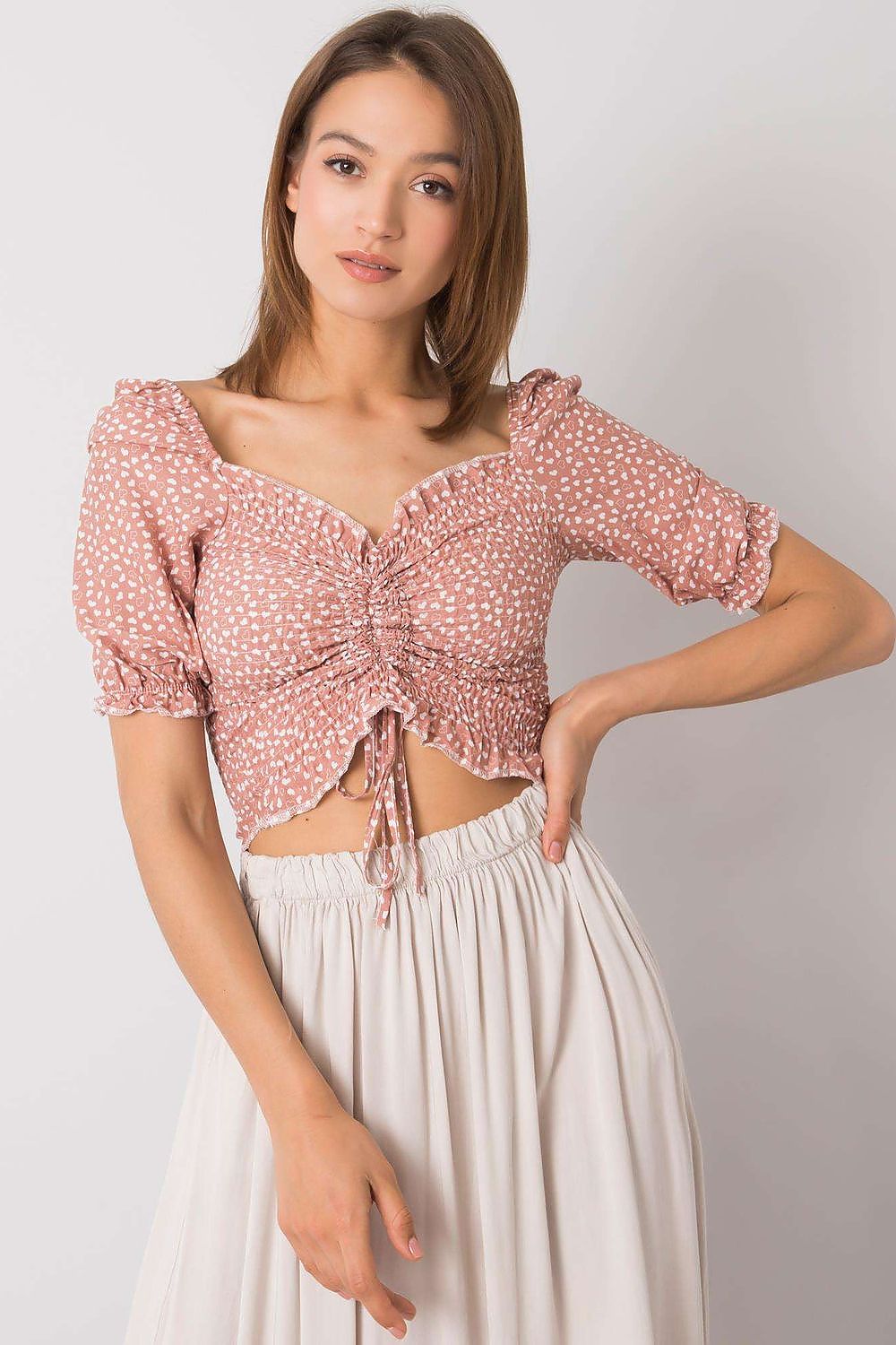 Elegant Rue Paris Fitted Cotton Spandex Blouse with V-Neck and Short Sleeves, showcasing a stylish model in a soft pink hue with a unique ruched design.