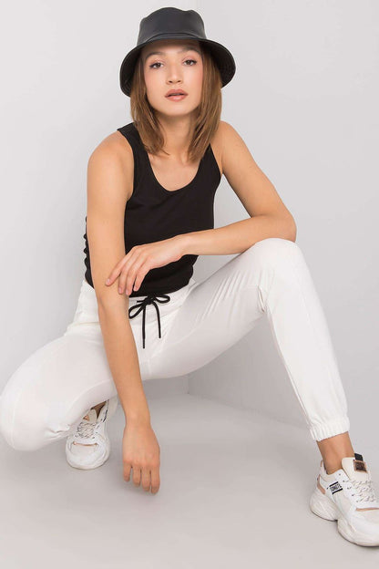 Stylish model showcasing the Rue Paris Women's 3-Piece Set, featuring a chic black sleeveless T-shirt and elegant white trousers with a relaxed fit. The ensemble is perfect for sophisticated casual looks.
