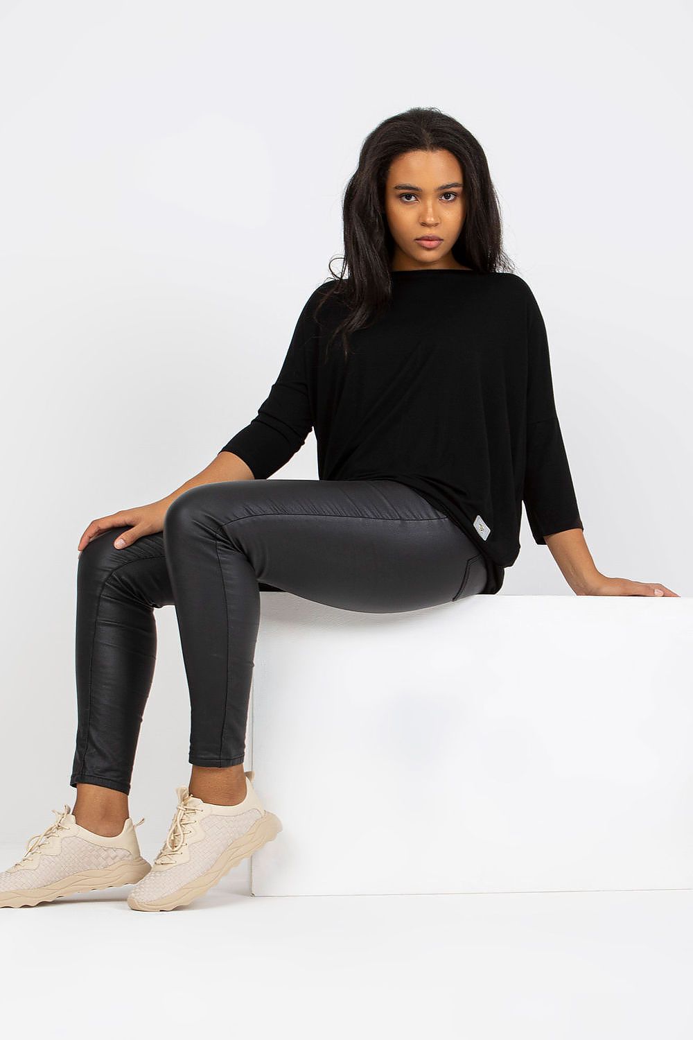 Luxury Plus Size Blouse with 3/4 Sleeves and Boat Neckline in Cotton and Spandex Blend, model seated elegantly showcasing the blouse, styled with sleek black pants.