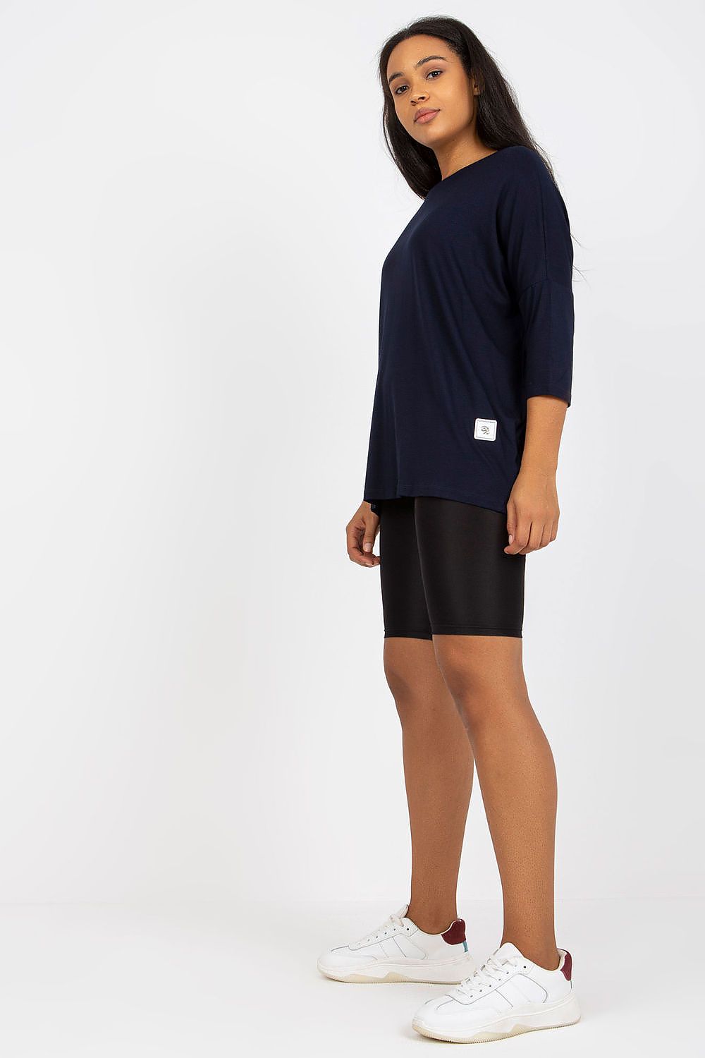 Luxury plus size blouse with 3/4 sleeves and boat neckline in cotton and spandex blend, modeled in navy with black shorts.