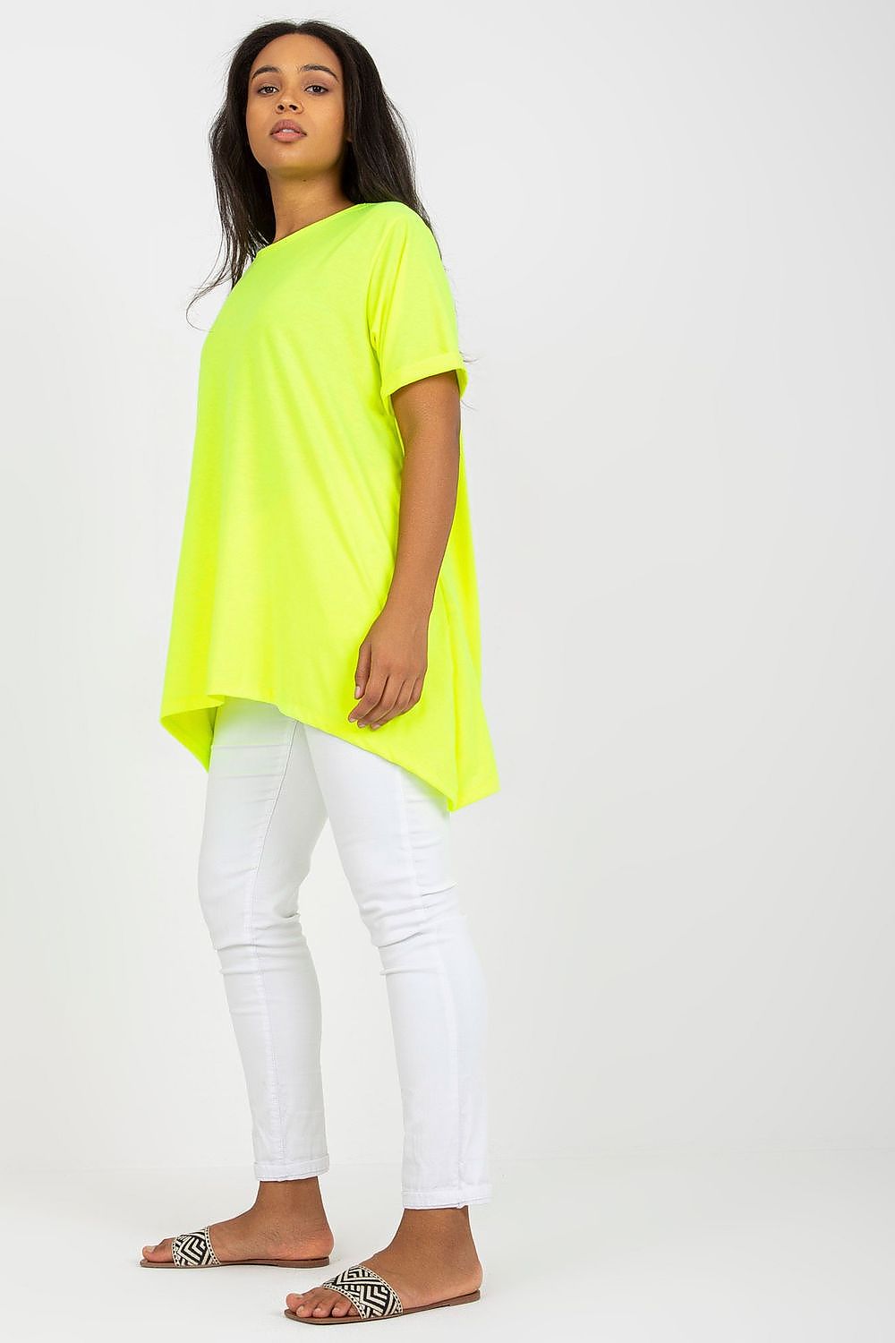 Stylish Plus Size Tunic with Short Sleeves and Asymmetrical Hemline - Boat Neck Design showcased on a model, featuring a vibrant neon yellow colour paired with white skinny jeans.